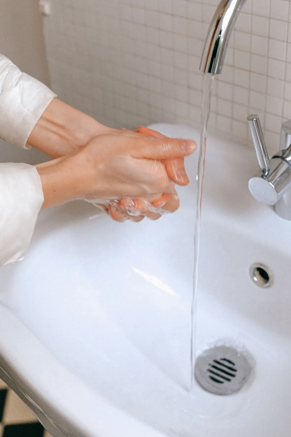 Đôi tay được rửa với xà phòng dưới vòi nước